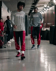 Two Men Are Walking Down A Hallway And One Has A Shirt That Says Reebok On It GIF