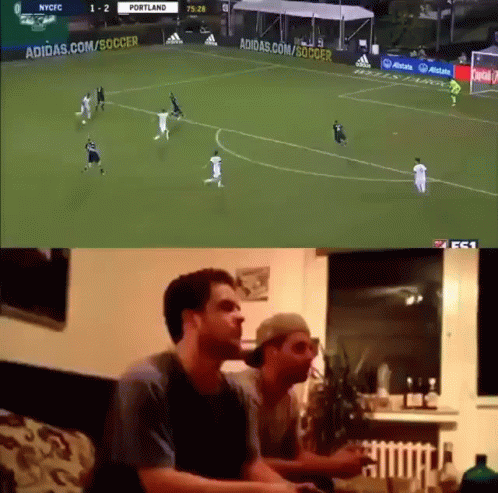 Two Men Are Watching A Soccer Game On A Tv Screen GIF