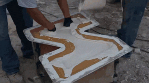 Two Men Are Working On A Piece Of Plastic That Looks Like A Cross GIF