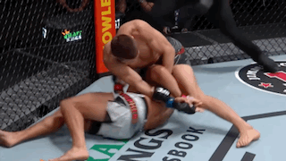 Two Men Are Wrestling In A Cage With A Referee Watching . GIF