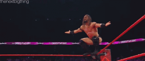 two men are wrestling in a ring and one of them is laying on the ground .