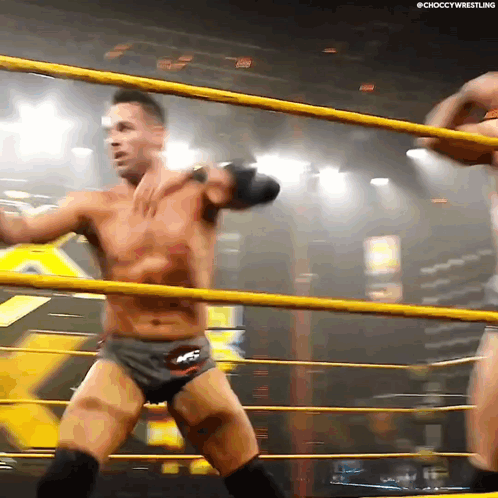 Two Men Are Wrestling In A Ring And One Of Them Is Wearing Shorts That Say Ncs GIF