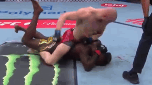 Two Men Are Wrestling In A Ring With A Monster Energy Logo On The Floor GIF