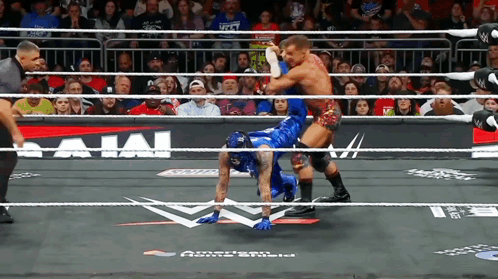 Two Men Are Wrestling In A Ring With A Sign That Says Bajai On It GIF