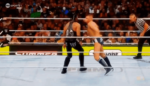 Two Men Are Wrestling In A Ring With A Sign That Says Tnt Sports GIF