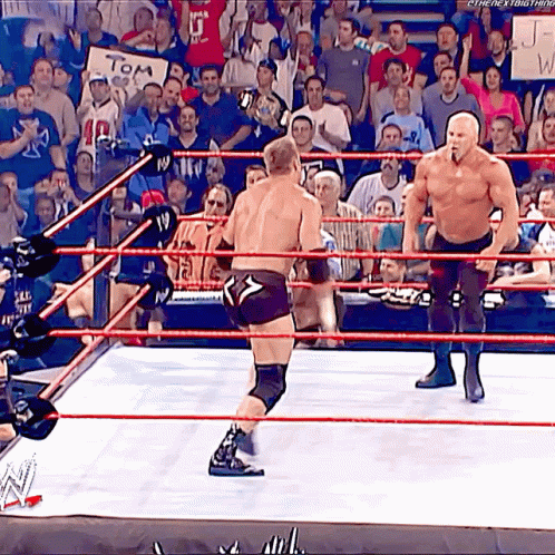 Two Men Are Wrestling In A Ring With A Sign That Says Tom GIF