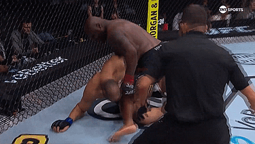 Two Men Are Wrestling In A Ring With A Yellow Sign That Says Morgan & Organ GIF