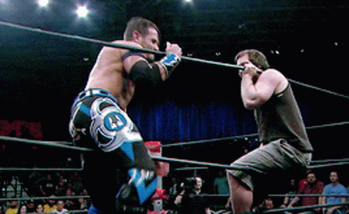 Two Men Are Wrestling In A Ring With One Wearing A Pair Of Shorts That Say J.j. GIF