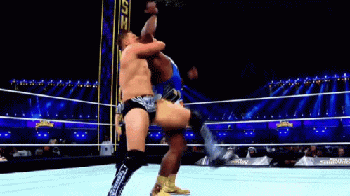 Two Men Are Wrestling In A Wrestling Ring And One Is Kicking The Other . GIF