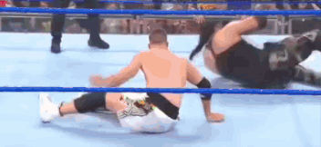 Two Men Are Wrestling In A Wrestling Ring And One Is Laying On The Ground . GIF