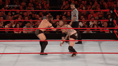 Two Men Are Wrestling In A Wrestling Ring With A Referee And #Wweukct Written On The Screen GIF