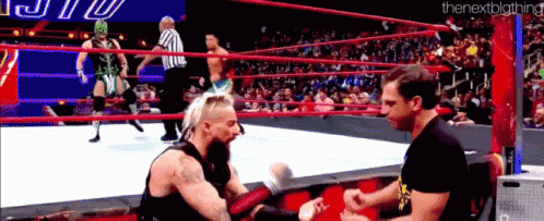 two men are wrestling in a wrestling ring with a referee watching .
