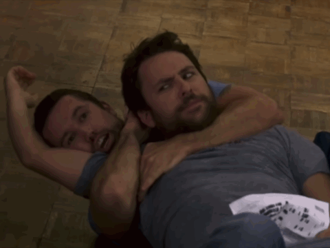 Two Men Are Wrestling On A Wooden Floor And One Of Them Has A Shirt That Says Ninja GIF