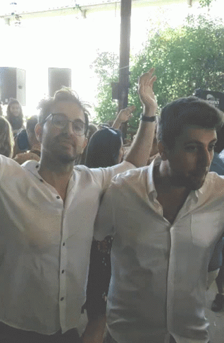 Two Men Arms Outstretched In Crowd With Corona Sign GIF