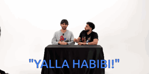 Two Men at Table Saying Yalla Habibi