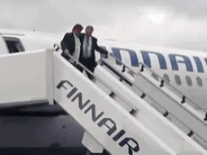 Two Men Boarding Finnair Plane On Cloudy Day GIF