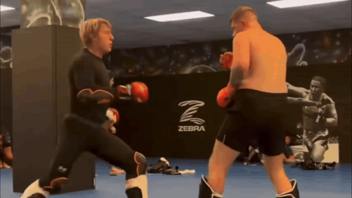 Two Men Boxing in Gym With Zebra Logo