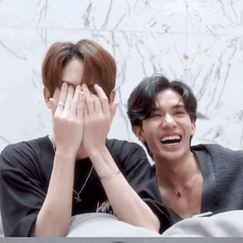 Two Men Covering Faces, One With Ring