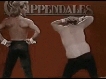 Two Men Dancing in Front of Appendales Sign