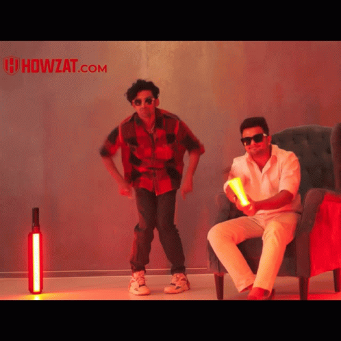 Two Men Dancing In Front Of Howzat.com GIF