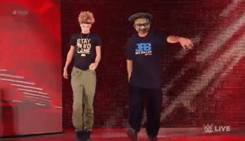 Two Men Dancing in Front of Raw Sign