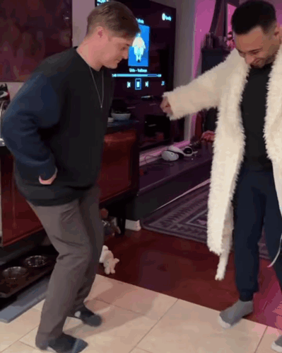 Two Men Dancing in Living Room With Netflix TV