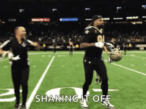 Two Men Dancing On Football Field Saying Shaking It Off GIF