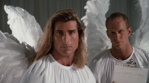 two men dressed as angels are standing next to each other and one is holding a clipboard