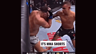 Two Men Fighting in Boxing Ring It's MMA Shorts