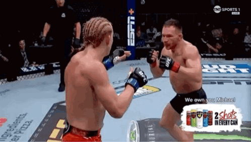 Two Men Fighting in Boxing Ring With 2 Shots in Every Can