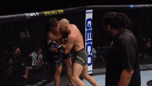Two Men Fighting in Boxing Ring with Geico Sign