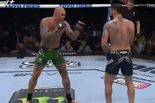 Two Men Fighting In Boxing Ring With Referee Watching