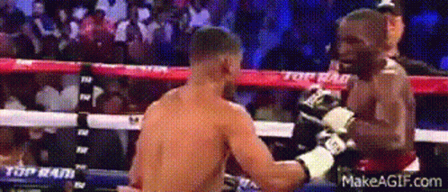 Two Men Fighting in Boxing Ring With Top on Ropes