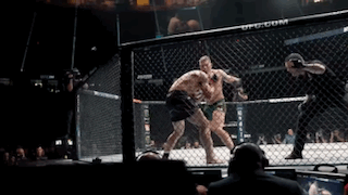 Two Men Fighting In Cage With Crowd And Referee GIF
