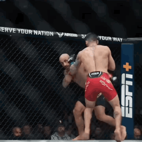 Two Men Fighting in Cage With ESPN Sign