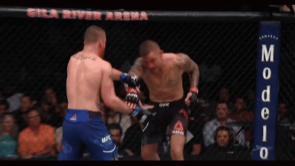 Two Men Fighting in Ring with Modelo Sign