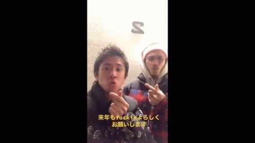 two men giving the middle finger in front of a sign that says s
