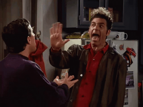 Two Men High Fiving in Front of Refrigerator