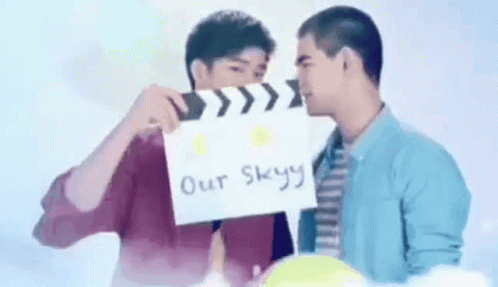 Two Men Holding Clapper Board Over Faces
