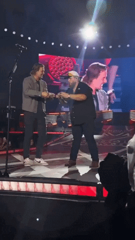 Two Men Holding Hands on Stage