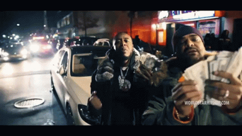 Two Men Holding Money In Front Of A Car With The Website Worldstarhiphop.com Visible GIF
