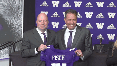 Two Men Holding Purple Jersey Saying Fisch