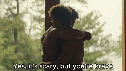 two men hugging each other with the words " yes , it 's scary but you 're brave " above them
