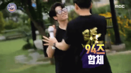 Two Men Hugging In Park, One In 94 Shirt GIF