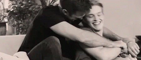 Two Men Hugging On Couch GIF