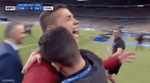 Two Men Hugging on Soccer Field