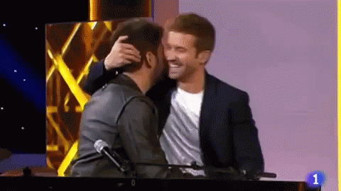 Two Men Hugging On Stage