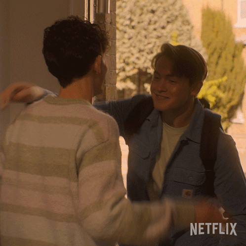Two Men Hugging With A Netflix Logo Behind Them GIF