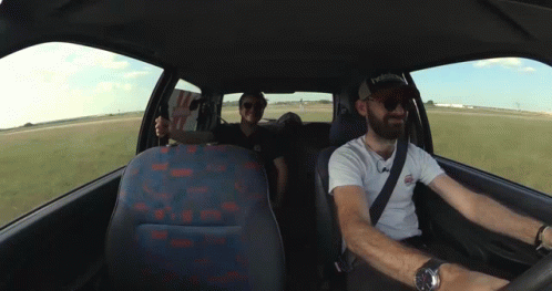 Two Men In A Car With One Wearing A Hat That Says Reebok On It GIF