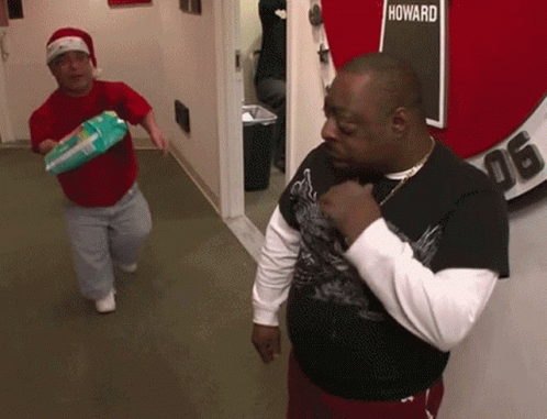 Two Men In A Hallway With A Sign That Says Howard GIF
